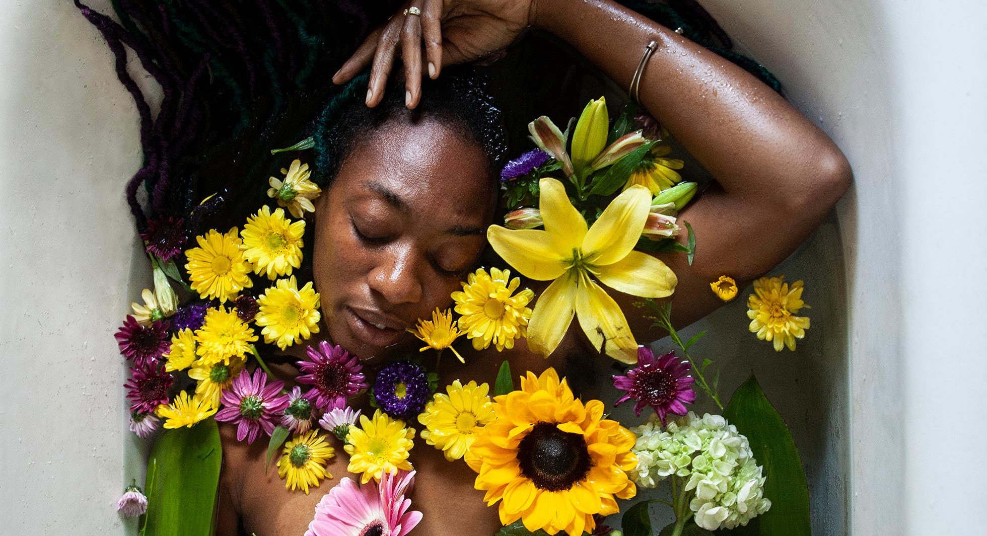 Woman with flowers around her head and shoulders against a white background
