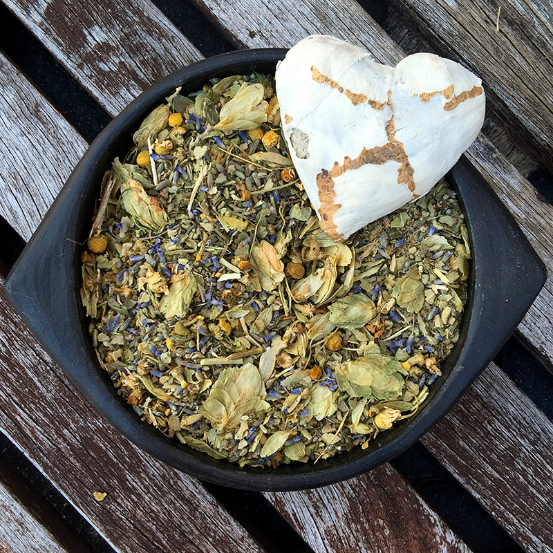 Purple and yellow flowers in a black bowl with a white paper heart – SLEEP herbal mix