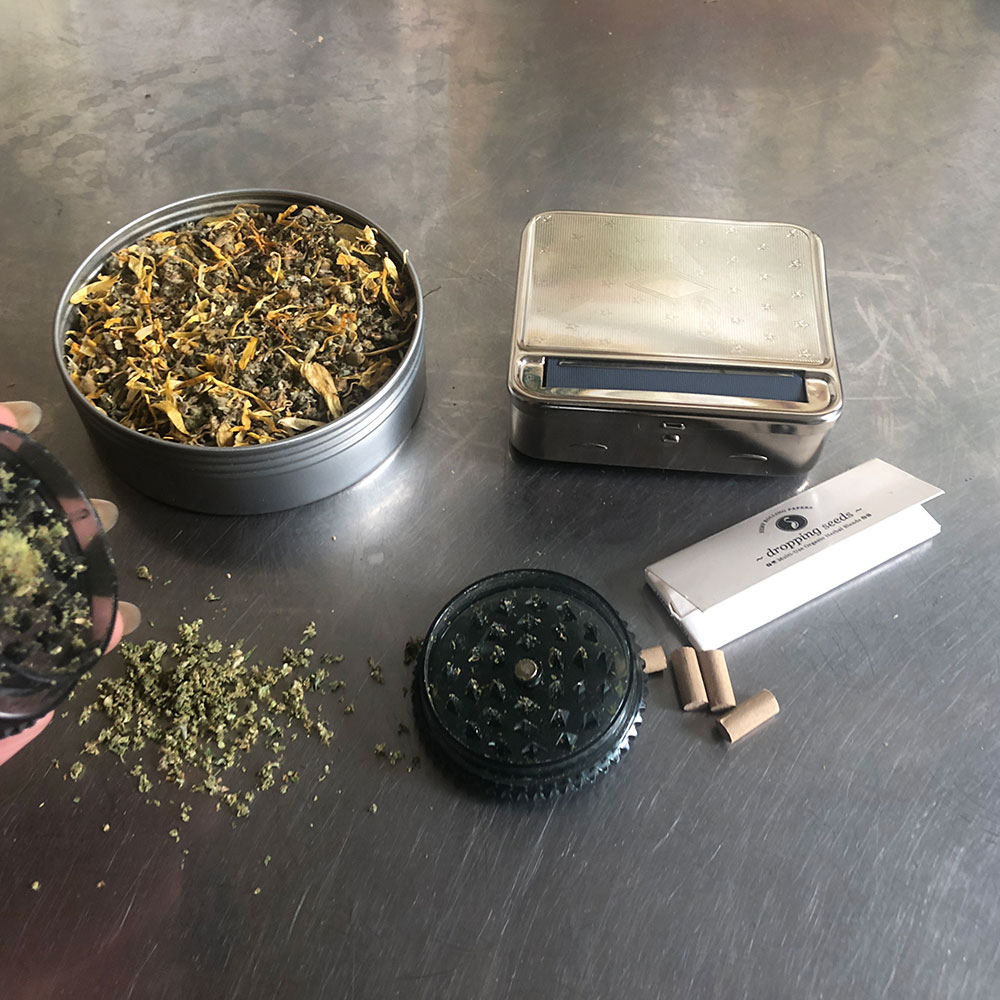 Step 2 Open herbal tin with rolling papers, rolling box and grind your herb.