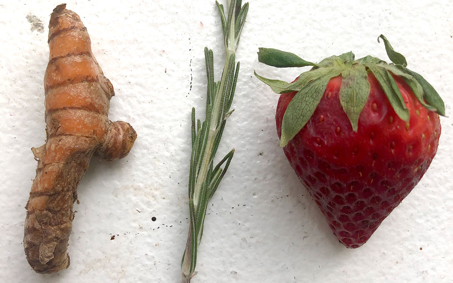 Tumeric root, rosemary and strawberry on white background